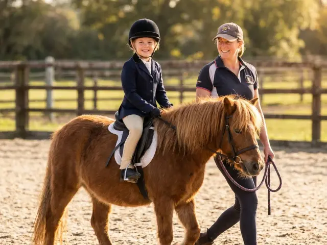 Kind nach der ersten Reitstunde, glücklich und schmutzig