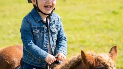 Kind zeigt selbstbewusst einem Pony eine Bürste