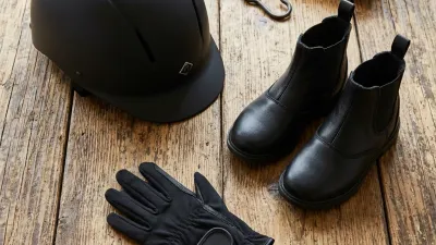 Ein Kind setzt einen Reithelm richtig auf.