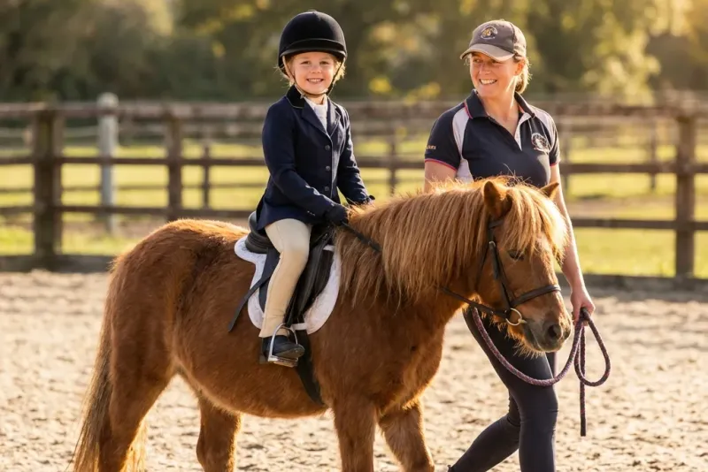 Kind nach der ersten Reitstunde, glücklich und schmutzig
